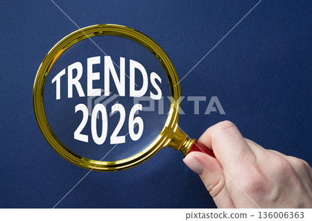 Trends 2026 symbol. Magnifying Glass with words Trends 2026. Businessman hand. Beautiful deep blue background. Business and Trends 2026 concept. Copy space. Trends 2026 symbol. Magnifying Glass with words Trends 2026. Businessman hand. Beautiful deep blue background. Business and Trends 2026 concept. Copy space. 136006363