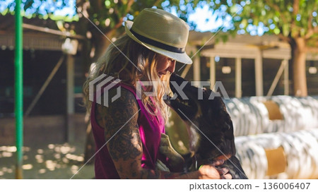 Woman with tattoos bonding with a dog outdoors Woman with tattoos bonding with a dog outdoors 136006407