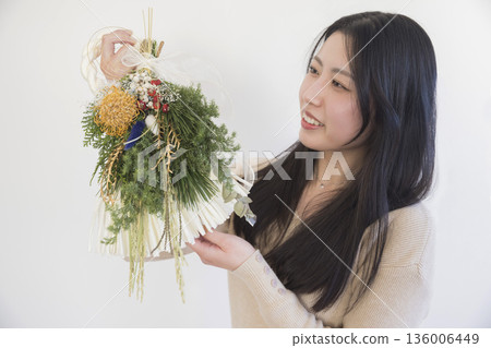 在註連繩製作工坊裡，年輕女性們正在觀看製作完成的注連繩。 136006449