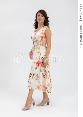 Elegant floral attire, Female model showcasing casual floral midi dress for campaigns, Seasonal fashion shoot featuring woman in soft floral outfit with relaxed stance Elegant floral attire, Female model showcasing casual floral midi dress for campaigns, Seasonal fashion shoot featuring woman in soft floral outfit with relaxed stance 136007547