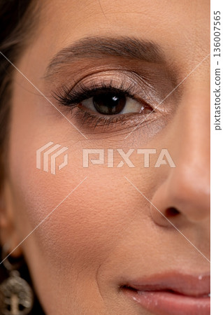 Closeup of radiant beauty, Beauty influencer with glittering cheek and subtle smile, Female model displaying luminous makeup with scattered sparkles and delicate earrings Closeup of radiant beauty, Beauty influencer with glittering cheek and subtle smile, Female model displaying luminous makeup with scattered sparkles and delicate earrings 136007565