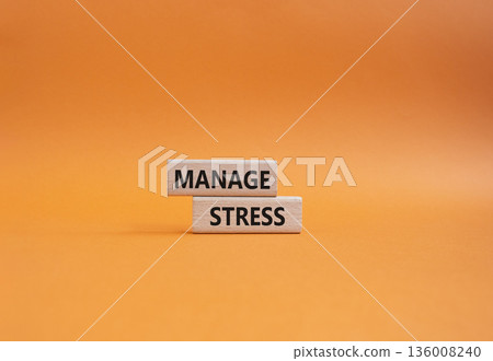 Manage stress symbol. Concept word Manage stress on wooden blocks. Beautiful orange background. Business and Manage stress concept. Copy space Manage stress symbol. Concept word Manage stress on wooden blocks. Beautiful orange background. Business and Manage stress concept. Copy space 136008240
