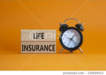 Life insurance symbol. Concept word Life insurance on wooden blocks. Beautiful orange background with alarm clock. Business and Life insurance concept. Copy space Life insurance symbol. Concept word Life insurance on wooden blocks. Beautiful orange background with alarm clock. Business and Life insurance concept. Copy space 136008423