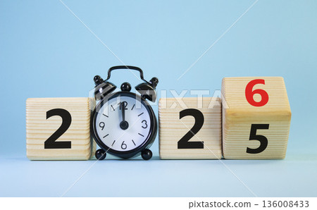 2026 New Year symbol. Businessman turns wooden cube and changes Year 2025 to 2026. Beautiful light blue background with Alarm clock. Copy space. Business and 2026 happy new year concept 2026 New Year symbol. Businessman turns wooden cube and changes Year 2025 to 2026. Beautiful light blue background with Alarm clock. Copy space. Business and 2026 happy new year concept 136008433