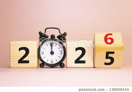 2026 New Year symbol. Businessman turns wooden cube and changes Year 2025 to 2026. Beautiful pink background with Alarm clock. Copy space. Business and 2026 happy new year concept 2026 New Year symbol. Businessman turns wooden cube and changes Year 2025 to 2026. Beautiful pink background with Alarm clock. Copy space. Business and 2026 happy new year concept 136008434