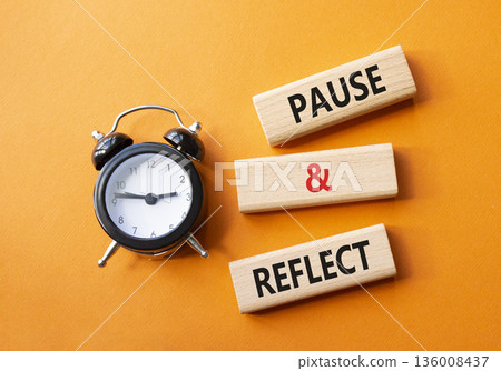 Pause and Reflect symbol. Concept words Pause and Reflect on wooden blocks. Beautiful orange background with alarm clock. Business and Pause and Reflect concept. Copy space. 136008437