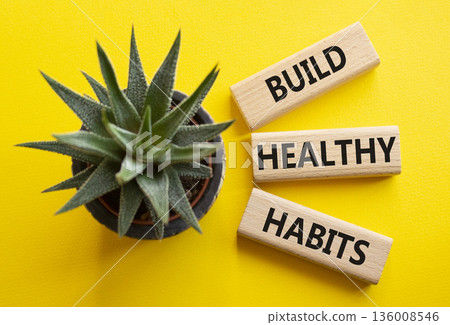 Healthy habits symbol. Concept word Build Healthy habits on wooden blocks with succulent. Beautiful yellow background. Healthy lifestyle and Healthy habits concept. Copy space 136008546