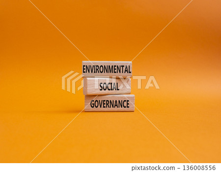 Wooden blocks displaying the words Environmental, Social, and Governance on a vibrant orange background, representing the concept of sustainable business practices and corporate responsibility. Copy Wooden blocks displaying the words Environmental, Social, and Governance on a vibrant orange background, representing the concept of sustainable business practices and corporate responsibility. Copy 136008556