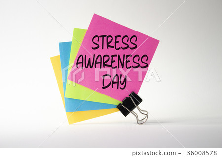 Stress Awareness Day symbol. Pink sticky note with paper clips with words Stress Awareness Day. Beautiful white background. Business and Stress Awareness Day concept. Copy space. 136008578