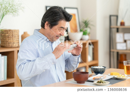 Middle-aged man eating at home 136008636