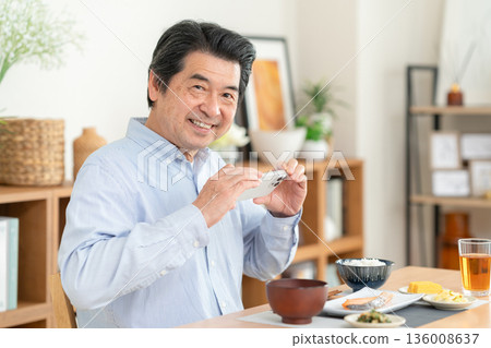 Middle-aged man eating at home Middle-aged man eating at home 136008637
