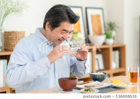 Middle-aged man eating at home 136008638