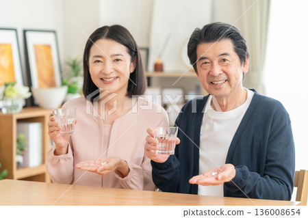 一對中年夫婦在家服用營養補充劑 136008654