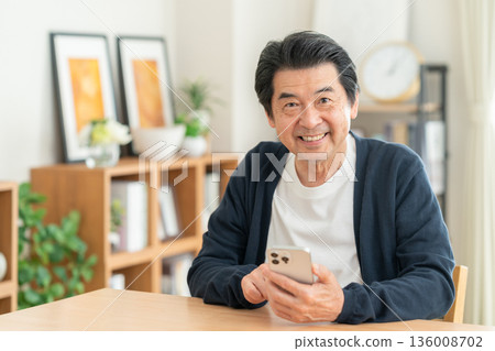 中間人在客廳裡看智能手機 136008702