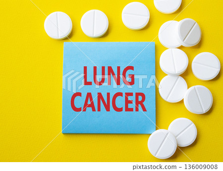 Lung Cancer symbol. Concept word Lung Cancer on blue note. Beautiful yellow background with pills. Medicine and Lung Cancer concept. Copy space 136009008