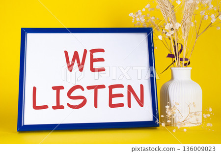 We listen symbol. Concept words We listen on beautiful wooden picture frame. Beautiful yellow background with flower vase. Business and We listen concept. Copy space. We listen symbol. Concept words We listen on beautiful wooden picture frame. Beautiful yellow background with flower vase. Business and We listen concept. Copy space. 136009023