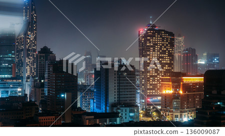 Shanghai city skyline at night with illuminated skyscrapers and vibrant urban lights Shanghai city skyline at night with illuminated skyscrapers and vibrant urban lights 136009087
