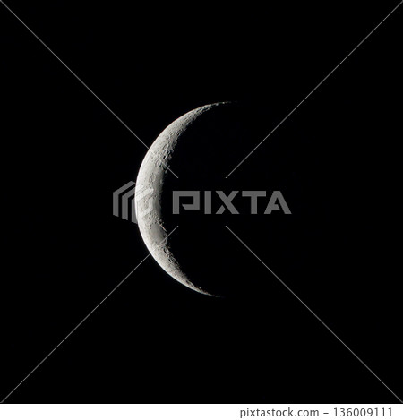 Crescent Moon Against Black Sky with Lunar Surface Details 136009111