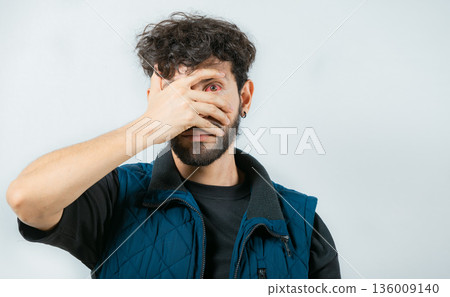 Person with eye infection looking at camera. Close up of man with red eyes suffering from conjunctivitis isolated Person with eye infection looking at camera. Close up of man with red eyes suffering from conjunctivitis isolated 136009140