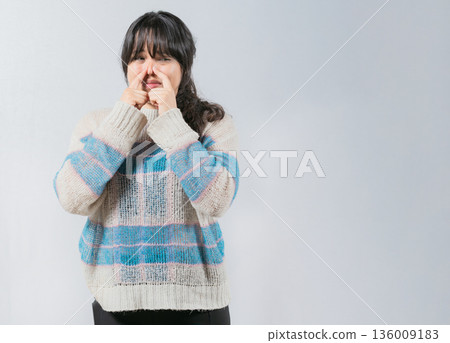 Asian woman covering nose because bad smells. Asian girl with a face from unpleasant odors. Concept of bad smells 136009183