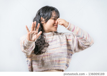 Bad smells: Asian woman covering nose because bad smells. Young woman with face of unpleasant odors, covering nose 136009189