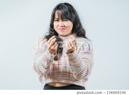 Cunning woman rubbing fingers showing money gesture isolated. Asian girl rubbing fingers asking for cash 136009190