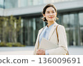 Businesswoman walking in front of an office building 136009691
