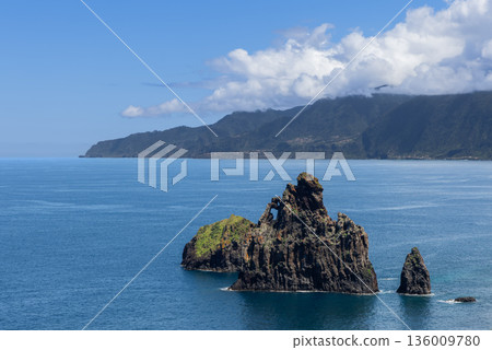 Rocky sea stacks Ilheus da Ribeira da Janela rise from calm Atlantic waters Madeira coast lookout 136009780
