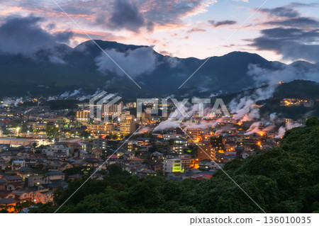 Beppu town in valley with hot spring smoke bath houses at dusk Beppu town in valley with hot spring smoke bath houses at dusk 136010035