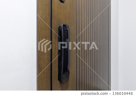 Contemporary smart door lock on wooden textured entrance door 136010448
