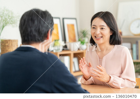 A middle-aged couple having a conversation in the living room A middle-aged couple having a conversation in the living room 136010470