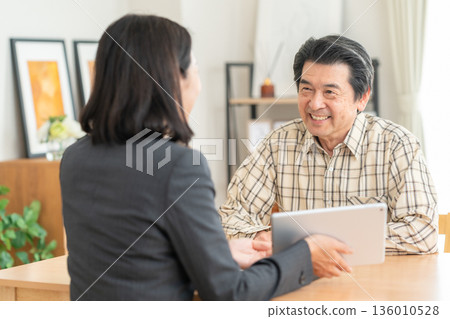 一位女商人正在客廳與一位男士談判 136010528