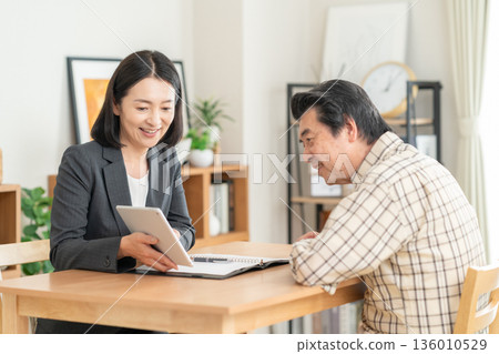 一位女商人正在客廳與一位男士談判 136010529