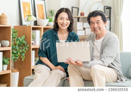 一對中年夫妻在家看電腦 136010550