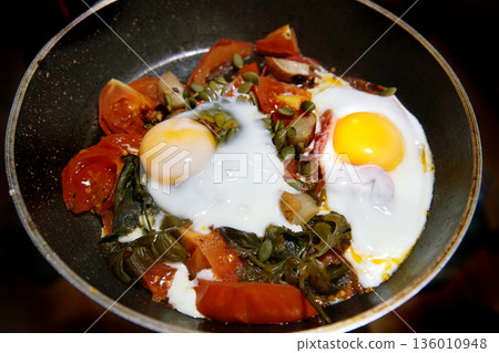 scrambled eggs with spinach, half a tomato and a few pumpkin seeds 136010948