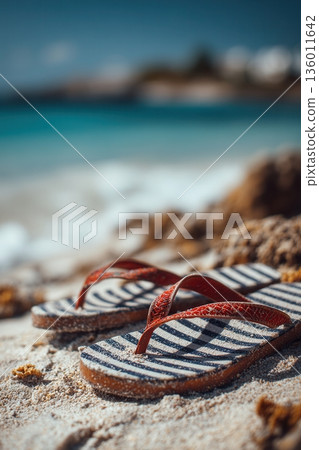 A single pair of flip-flops on clean sand 136011642