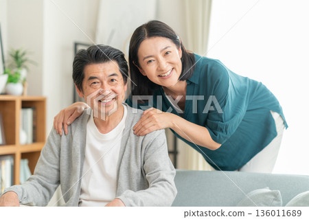 A middle-aged couple relaxing in the living room A middle-aged couple relaxing in the living room 136011689