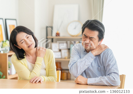 一對中年夫婦在客廳享受肩部按摩 136012133