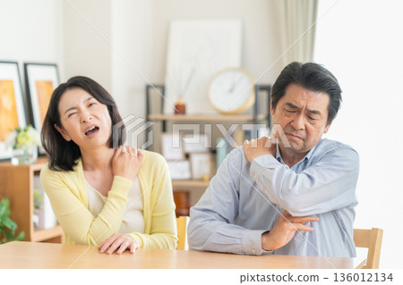 一對中年夫婦在客廳享受肩部按摩 136012134