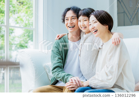 一家人友善地在客廳的沙發上放鬆。 136012296