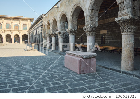 Stone arcade courtyard with arches and sarcophagus 136012323