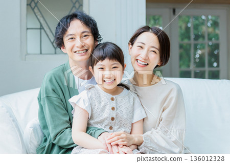 一家人友善地在客廳的沙發上放鬆。 136012328