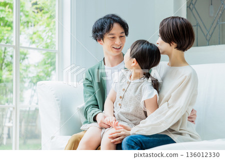 一家人友善地在客廳的沙發上放鬆。 136012330