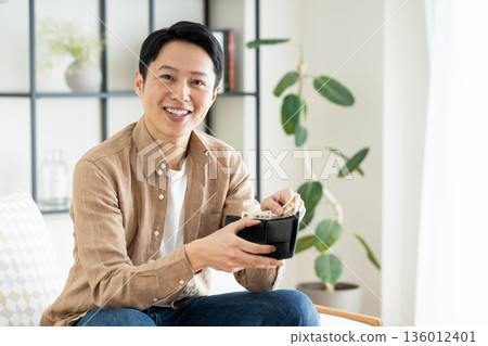 一位中年男子在客廳拿著錢包 136012401
