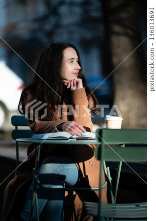 Contemplative afternoon at a green cafe table, a woman enjoys coffee while lost in thought in a charming urban street setting, capturing the essence of quiet moments Contemplative afternoon at a green cafe table, a woman enjoys coffee while lost in thought in a charming urban street setting, capturing the essence of quiet moments 136013691