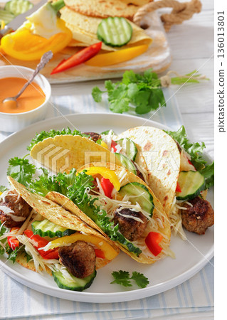 lamb meatball tacos with fresh veggies on a plate lamb meatball tacos with fresh veggies on a plate 136013801