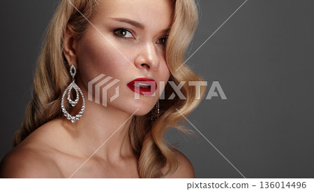 Closeup Beauty Shot Highlighting Ornate Earrings And Diamond Detail, Flawless Skin Texture, Rich Red Lips, Soft Curl Framing Face, Studio Lighting Creating Luminous Highlights, Jewelry Commercial 136014496