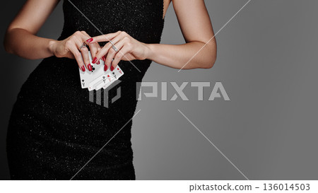 Graceful Lady Dressed For Evening Gaming. Elegant Woman In Sequined Attire Adopts Serious Poker Stance. Sophisticated Lady Donning Evening Gown Maintains Tense Poker Posture During Game 136014503