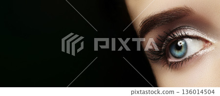 Closeup Blue Eye With Long Lashes, StudioLit Glamour Shot Showcasing Shimmer Eyeshadow, WellDefined Eyebrow, Crisp Skin Texture, Reflective Catchlight Creating Dramatic Mood, Makeup Model Showcasing 136014504