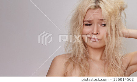 Frustrated Woman With Tangled Hair, Crimped Blonde Strands, Hand Behind Head, Annoyed Facial Expression, Neutral Background, Closeup Portrait Conveying Stress Over Hair Condition And Styling Dilemma Frustrated Woman With Tangled Hair, Crimped Blonde Strands, Hand Behind Head, Annoyed Facial Expression, Neutral Background, Closeup Portrait Conveying Stress Over Hair Condition And Styling Dilemma 136014508